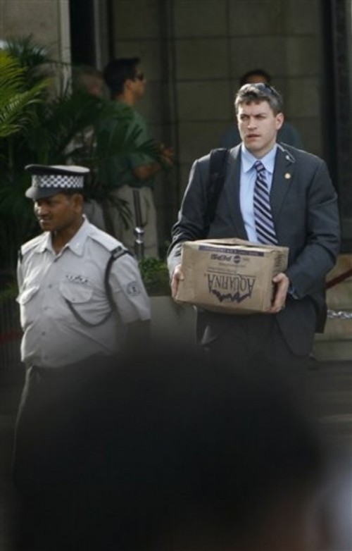 Security Official carries bottled water outside the Taj Mahal Hotel